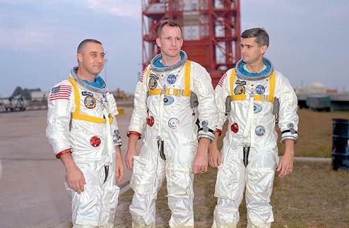 Grissom, White, and Chaffee in front of the launch pad containing their AS-204 space vehicle